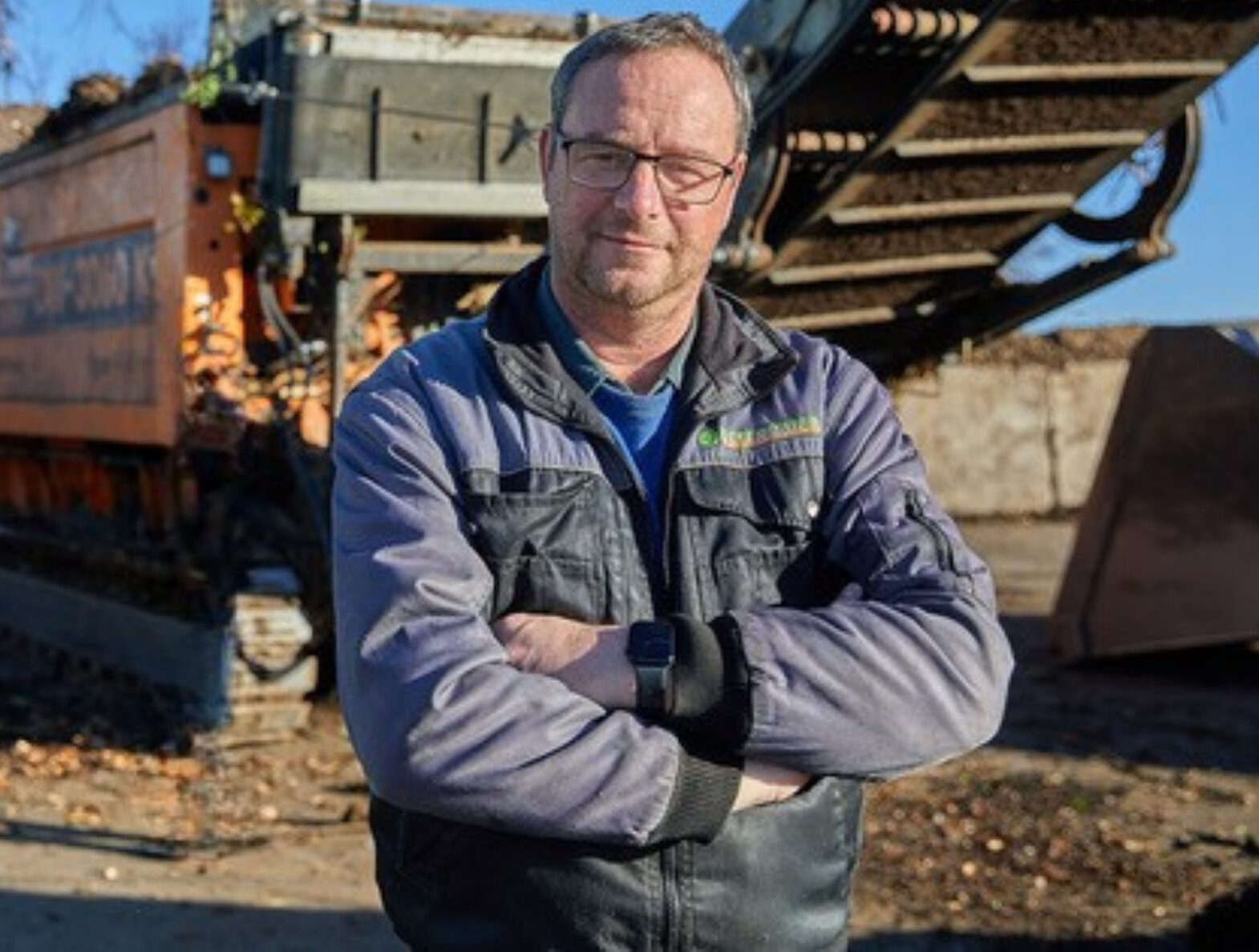 Josef Ostermaier steht mit eingeschränkten Armen vor einer Maschine.