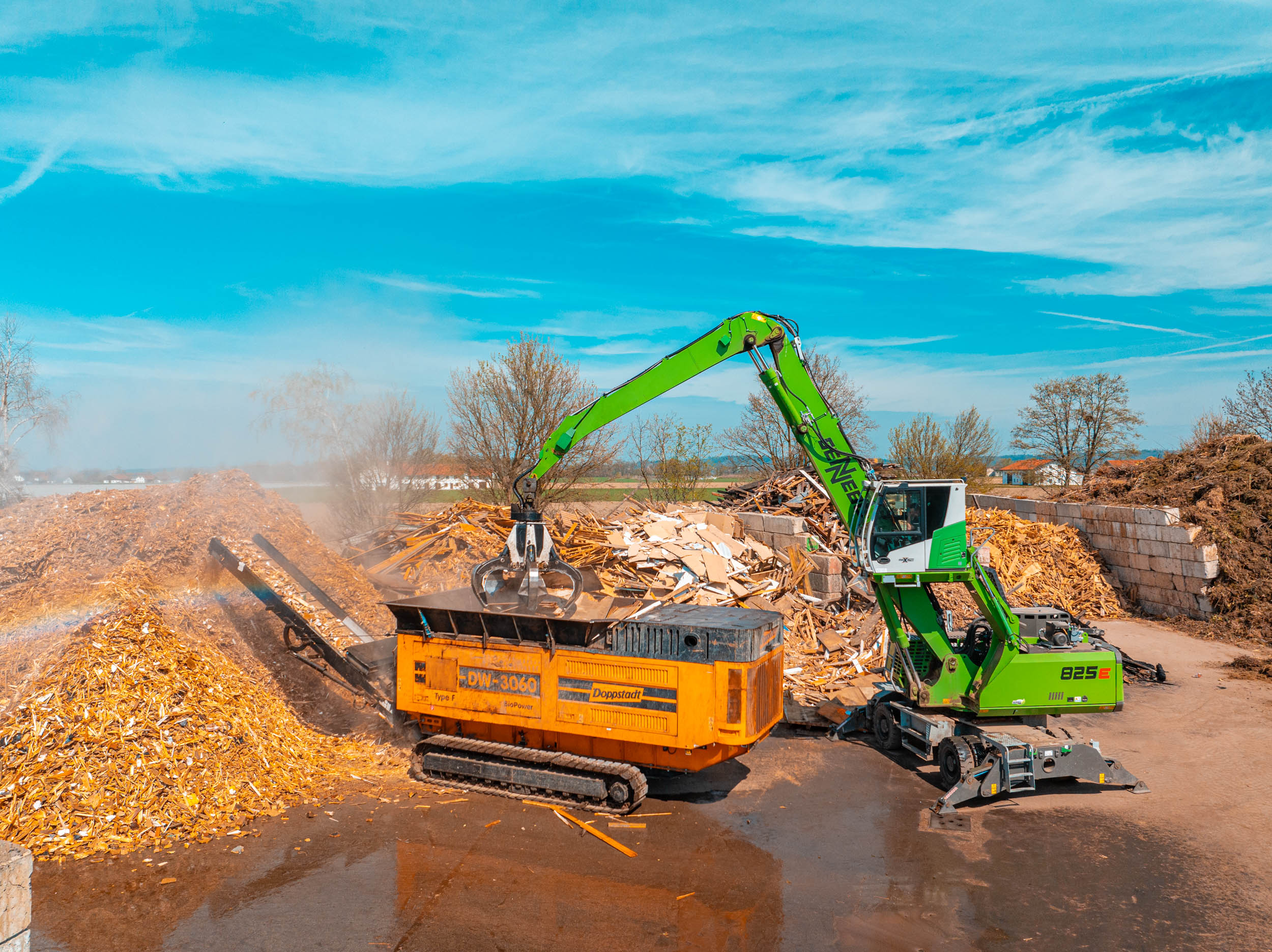 Moderner Umschlagbagger und Schredderanlage bei der Holzverwertung am Wertstoffhof von Ostermaier Dienstleistungen – effiziente Aufbereitung und Recycling von Altholz und Grünschnitt für nachhaltigen Umweltschutz.