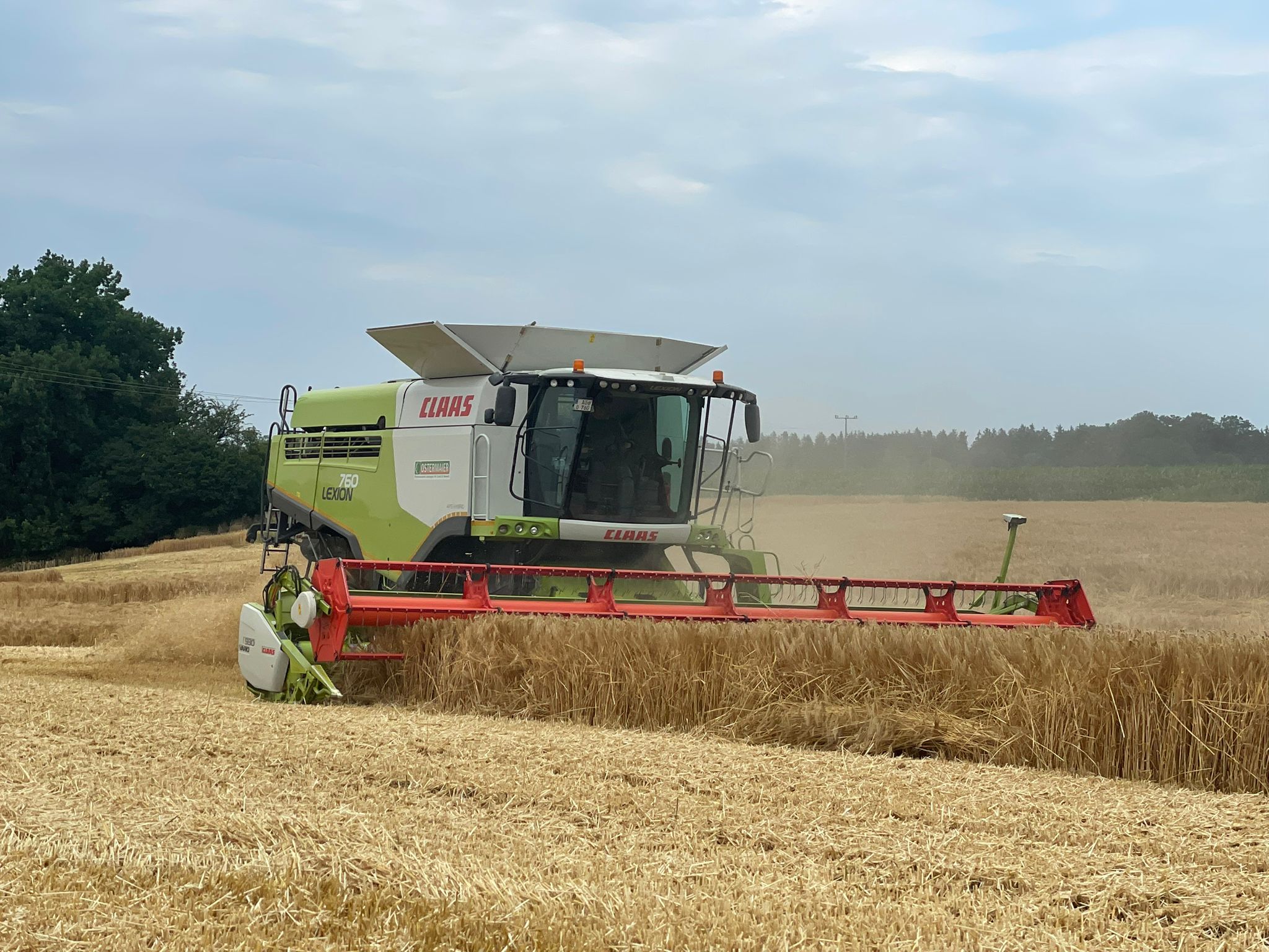 Claas Lexion 760 Mähdrescher bei der Getreideernte auf einem Feld – professionelle landwirtschaftliche Dienstleistungen von Ostermaier.